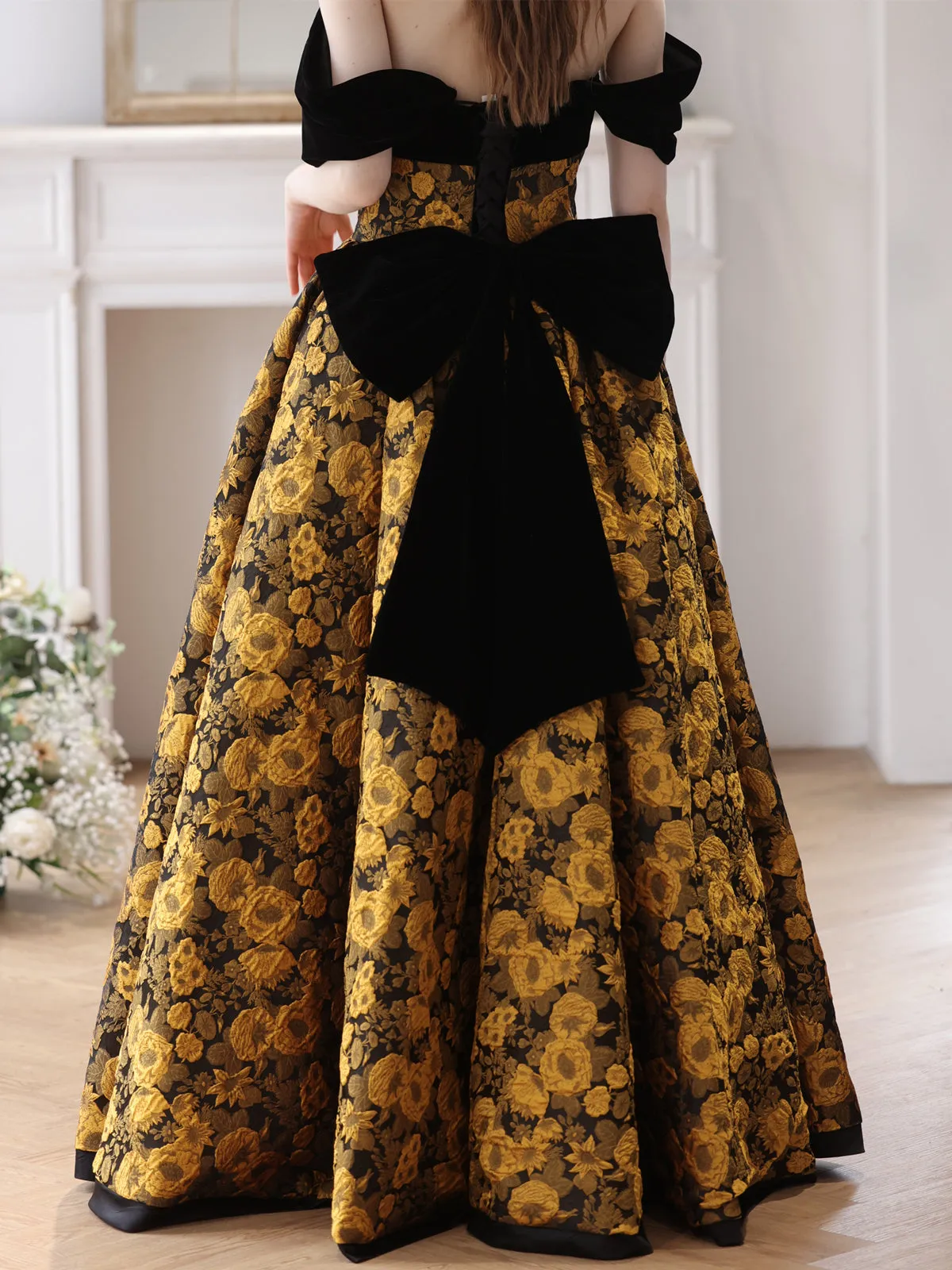 Elegant Black and Gold Floral Strapless Ball Gown with Bow Accent